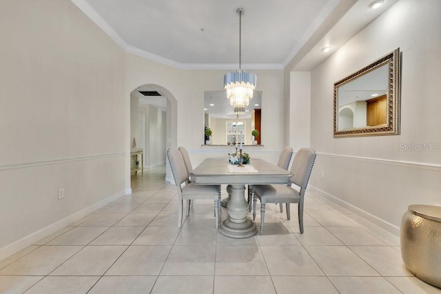 dining space with baseboards, an inviting chandelier, light tile patterned flooring, arched walkways, and ornamental molding