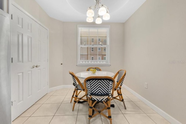 dining room with baseboards, a notable chandelier, and light tile patterned flooring