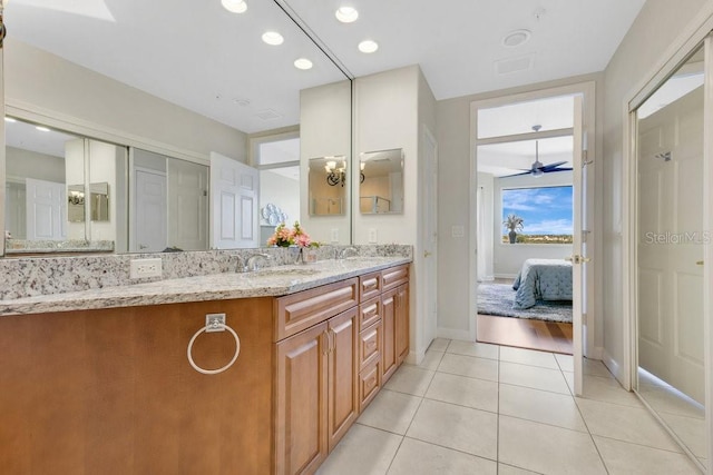 ensuite bathroom featuring a ceiling fan, ensuite bathroom, a sink, tile patterned flooring, and double vanity