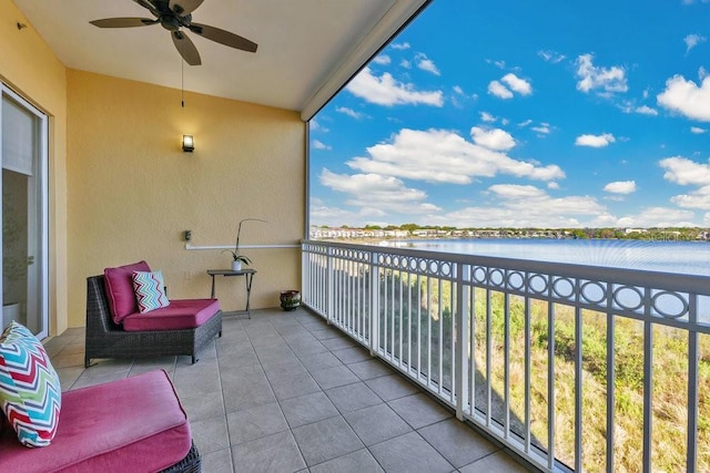 balcony featuring a water view and ceiling fan