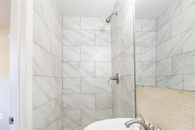 full bathroom featuring a sink and tiled shower