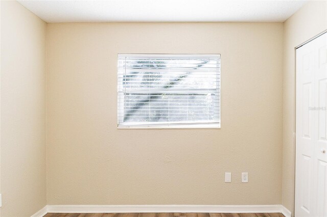 empty room with wood finished floors and baseboards