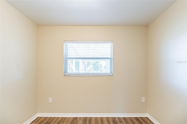 empty room with baseboards and wood finished floors