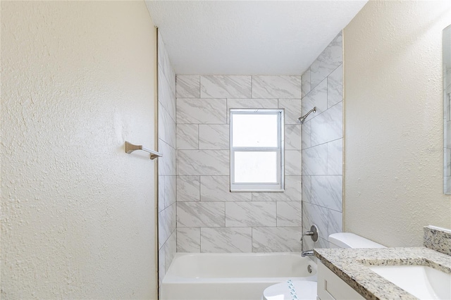 full bathroom with shower / bath combination, vanity, a textured wall, and toilet