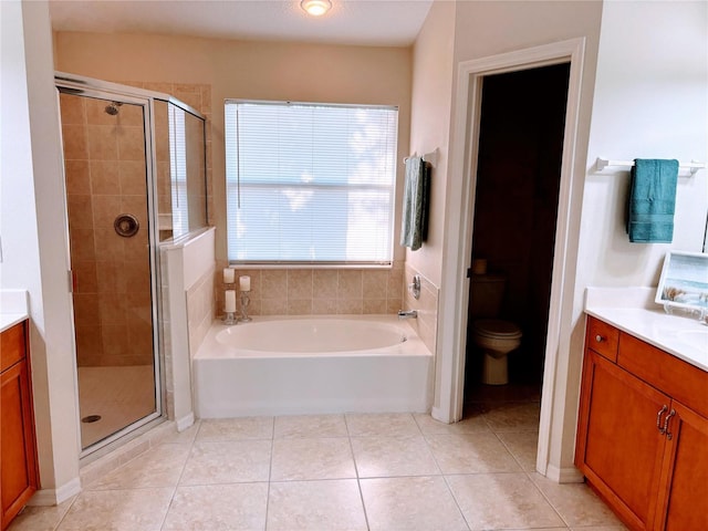 full bathroom with toilet, a stall shower, a bath, tile patterned floors, and vanity