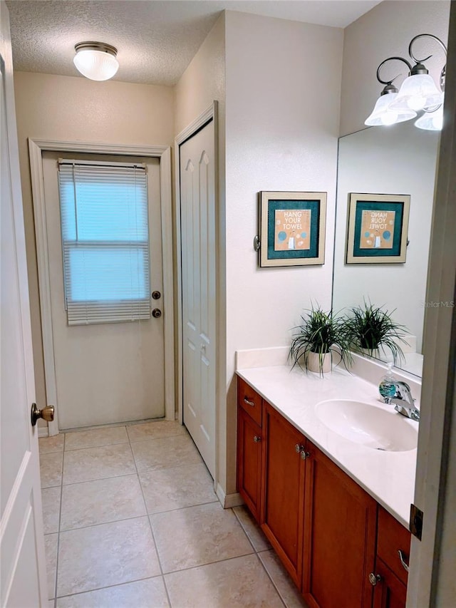 bathroom featuring tile patterned flooring, a textured ceiling, and vanity