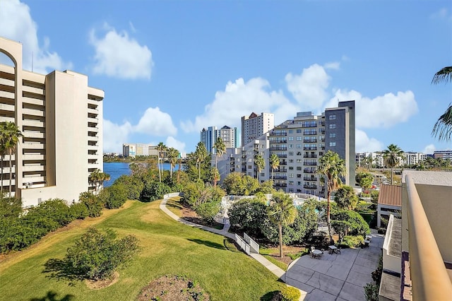 view of property's community with a city view, a yard, and a water view