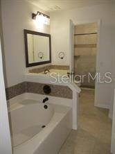 full bath featuring tile patterned floors and a tub to relax in