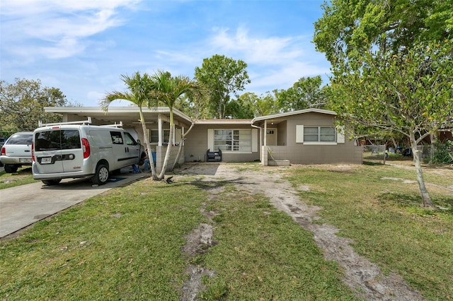 ranch-style house featuring driveway and a front lawn