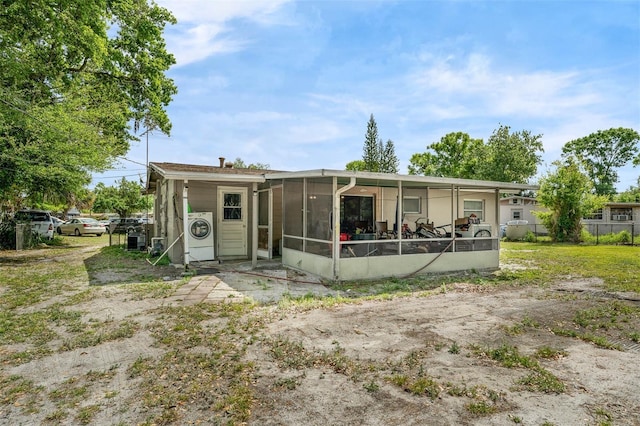 back of house with washer / dryer, fence, and a sunroom