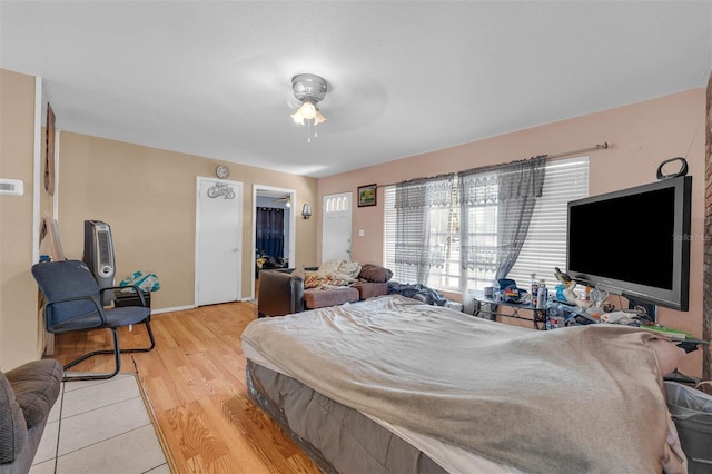 bedroom with baseboards, light wood finished floors, and ceiling fan