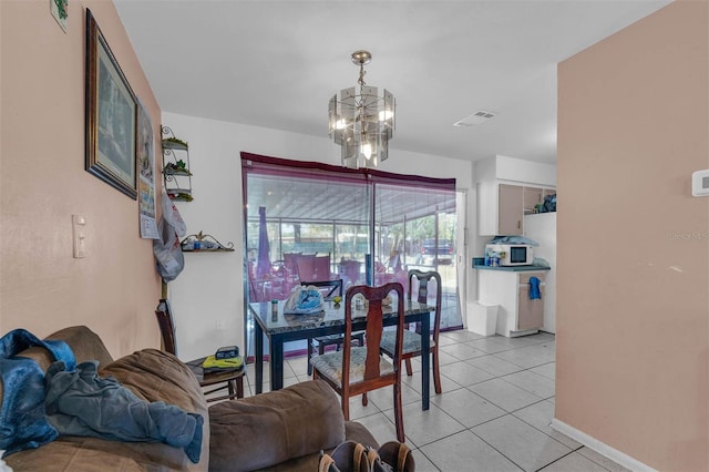 dining space featuring light tile patterned flooring, baseboards, visible vents, and a chandelier