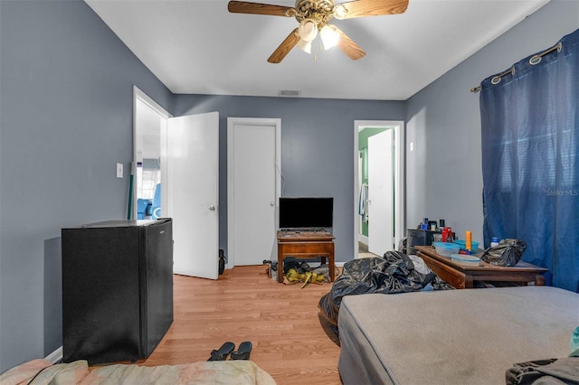 bedroom with visible vents, light wood-style flooring, and a ceiling fan