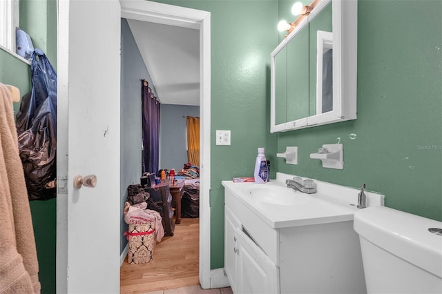 bathroom with vanity, toilet, and wood finished floors