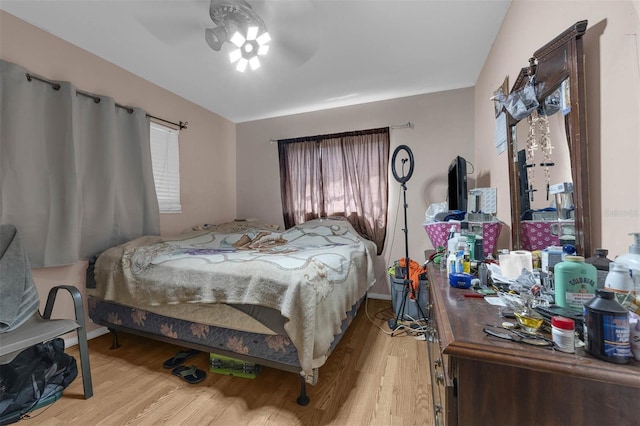 bedroom with baseboards, light wood-type flooring, and ceiling fan