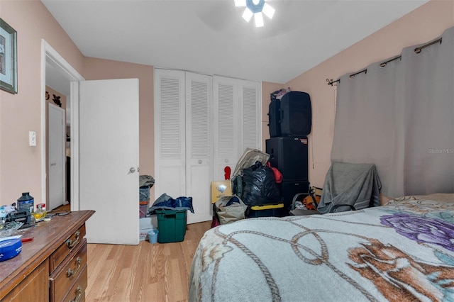 bedroom featuring light wood finished floors, ceiling fan, and a closet