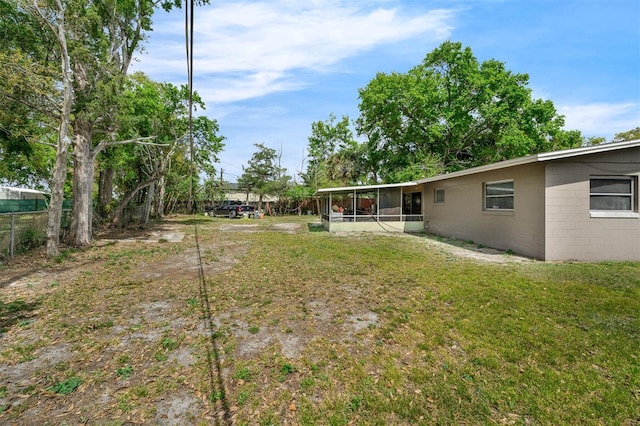 view of yard with fence and a sunroom