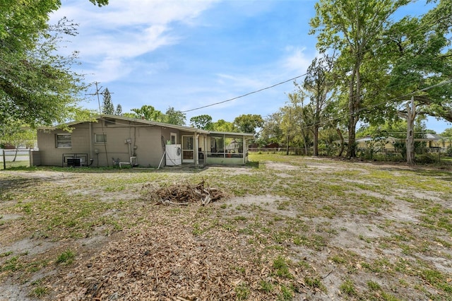 view of yard featuring fence and a sunroom