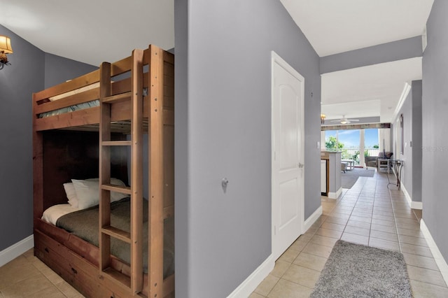 hallway featuring baseboards and light tile patterned flooring