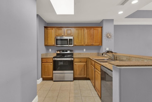 kitchen with visible vents, light tile patterned floors, appliances with stainless steel finishes, a peninsula, and a sink