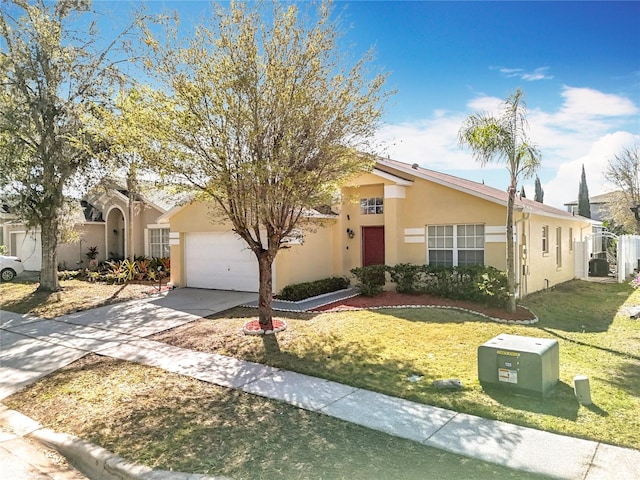 view of front of home featuring stucco siding, an attached garage, concrete driveway, and a front yard