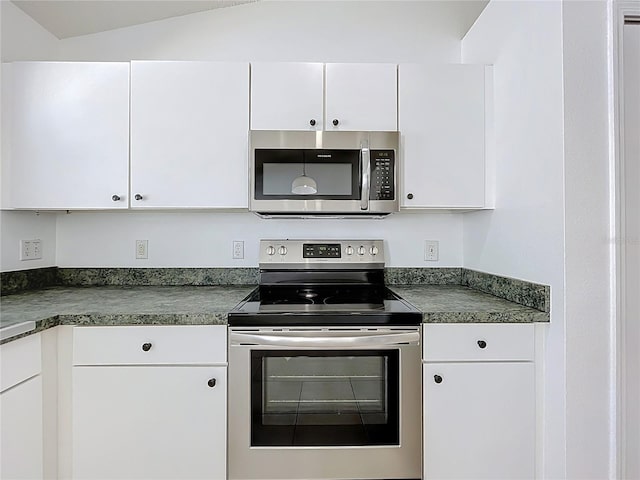 kitchen with stainless steel appliances, dark countertops, and white cabinets