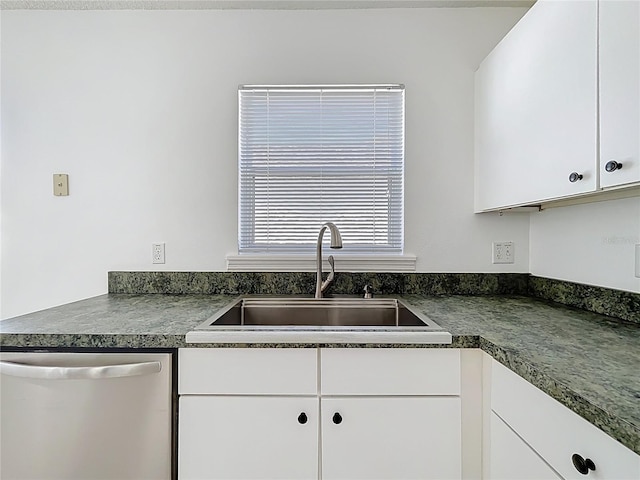 kitchen with dark countertops, dishwasher, white cabinetry, and a sink