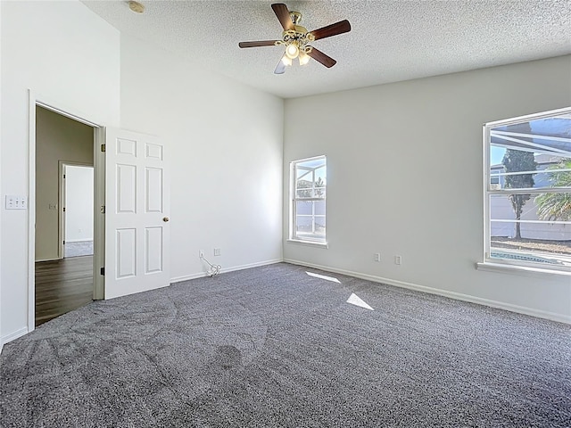 unfurnished room with carpet floors, plenty of natural light, and vaulted ceiling