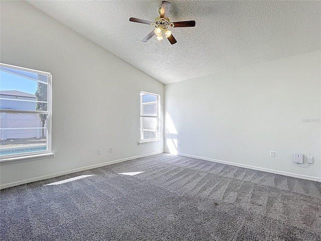 unfurnished room featuring baseboards, lofted ceiling, carpet floors, a textured ceiling, and a ceiling fan