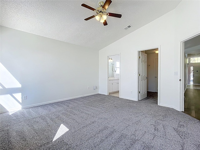 unfurnished bedroom featuring visible vents, baseboards, vaulted ceiling, carpet flooring, and a textured ceiling