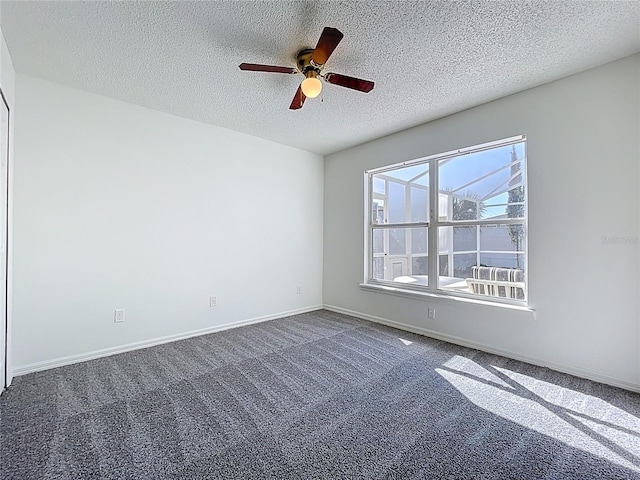 empty room featuring a textured ceiling, baseboards, carpet floors, and ceiling fan