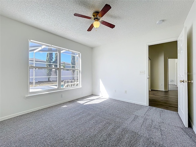 unfurnished bedroom with ceiling fan, carpet flooring, baseboards, and a textured ceiling