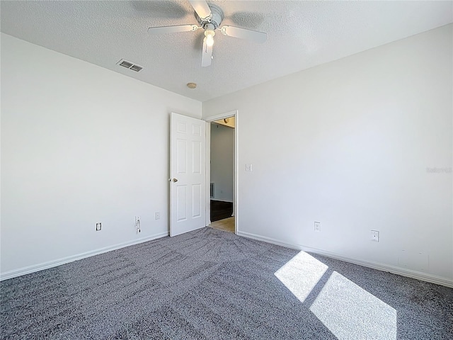 carpeted empty room featuring a textured ceiling, baseboards, visible vents, and ceiling fan