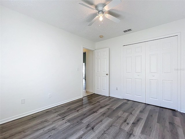 unfurnished bedroom featuring visible vents, baseboards, a textured ceiling, and wood finished floors