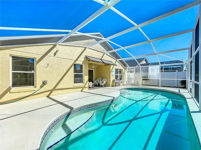 view of pool with glass enclosure, a patio area, a fenced in pool, and ceiling fan