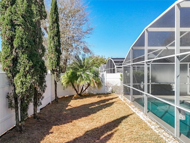 view of yard featuring a lanai, a fenced in pool, and a fenced backyard