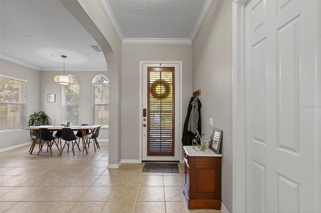 foyer with arched walkways, visible vents, crown molding, and light tile patterned floors