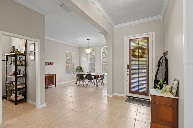 foyer featuring crown molding, light tile patterned flooring, arched walkways, and visible vents