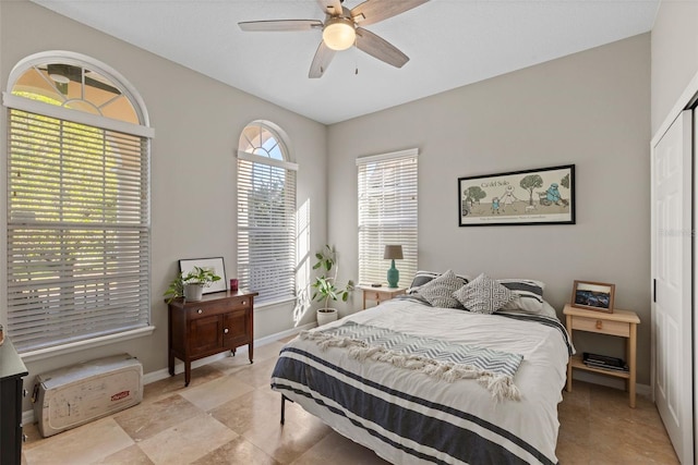 bedroom with baseboards, a closet, and ceiling fan