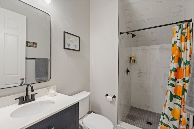 bathroom with vanity, toilet, and tiled shower