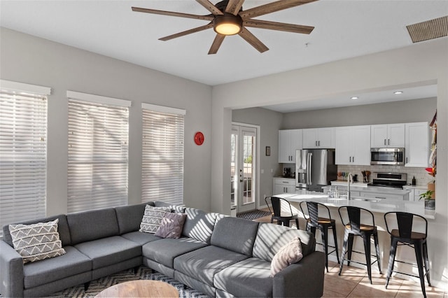 living area featuring light tile patterned floors, french doors, visible vents, and ceiling fan