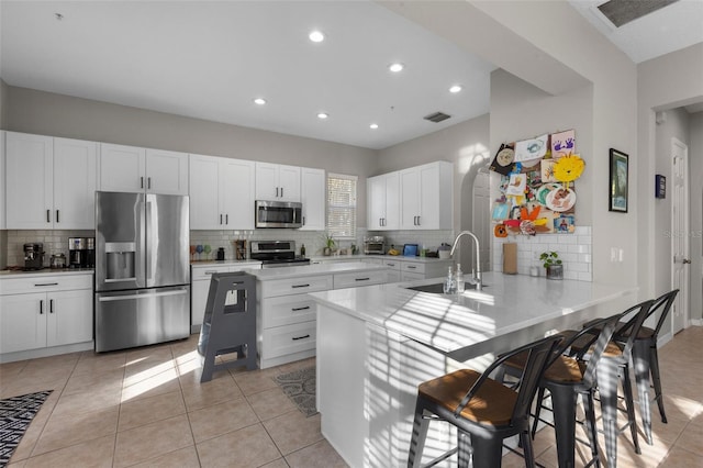 kitchen featuring a sink, visible vents, appliances with stainless steel finishes, and a peninsula