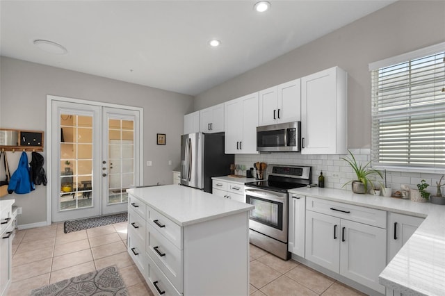 kitchen featuring decorative backsplash, light tile patterned flooring, french doors, and stainless steel appliances