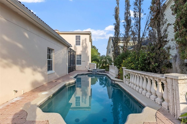 view of swimming pool with a patio and a pool with connected hot tub