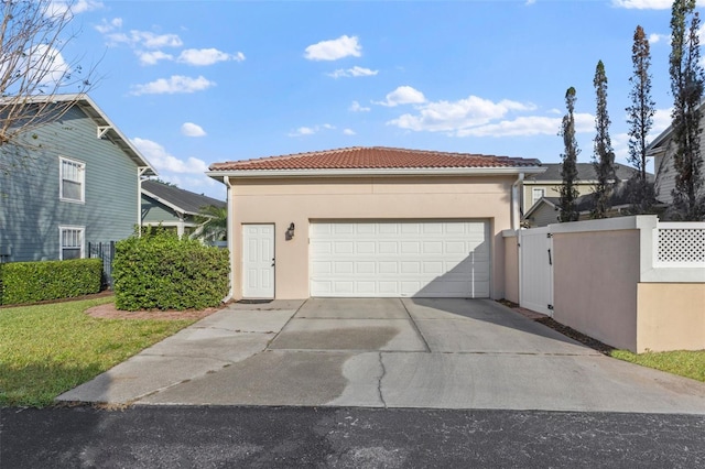 garage featuring concrete driveway and a gate