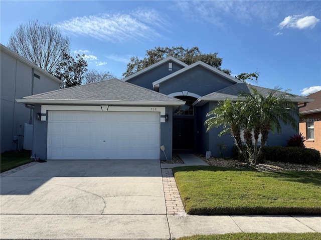 ranch-style home with stucco siding, driveway, a front yard, and a garage