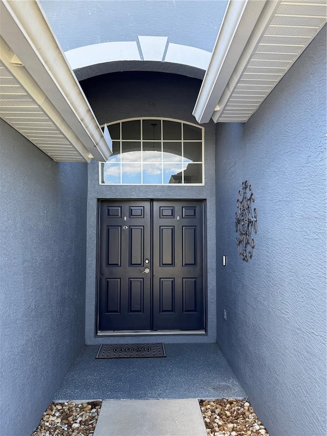 entrance to property with stucco siding