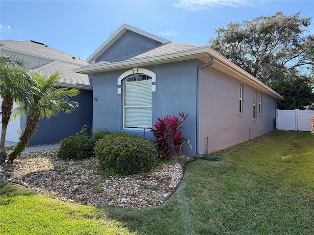 view of front of property featuring a front yard, fence, and stucco siding