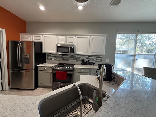 kitchen featuring tasteful backsplash, visible vents, appliances with stainless steel finishes, and light countertops