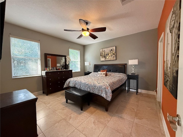 bedroom with baseboards, a textured ceiling, and a ceiling fan